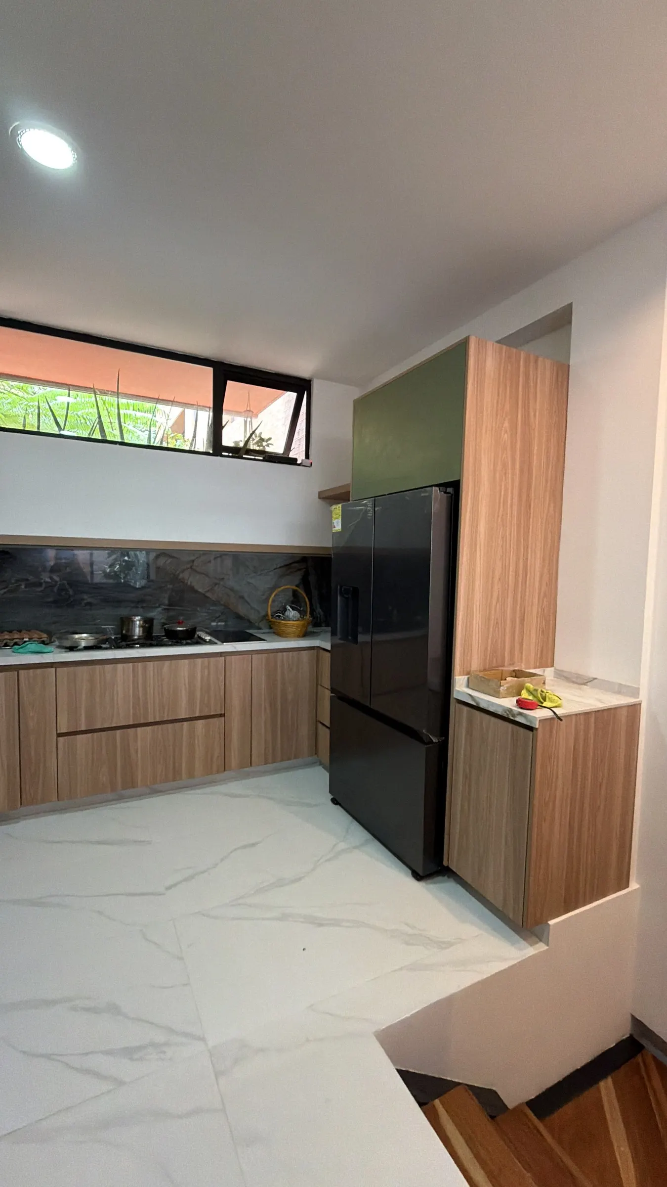 Cocina Casa 8 · Detalle del acanalado fino de madera y la piedra del mesón. · IO's Architecture